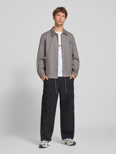 Männermodel trägt Relaxed Fit Blouson aus reiner Baumwolle Modell 'Biyo2631' von HUGO, Herren Bomberjacke, Grauton, Ganzkörperansicht von vorne.