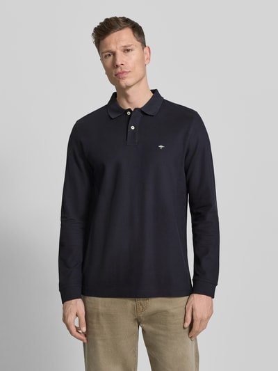 Männermodel trägt Poloshirt mit Label-Stitching von Fynch-Hatton in Dunkelblau, Reine Baumwolle, Regular-Fit, Polokragen, Knopfleiste, gerippte Ärmelabschlüsse, Rückenlänge bei Größe M 37 cm, Ganzkörperansicht von vorne.