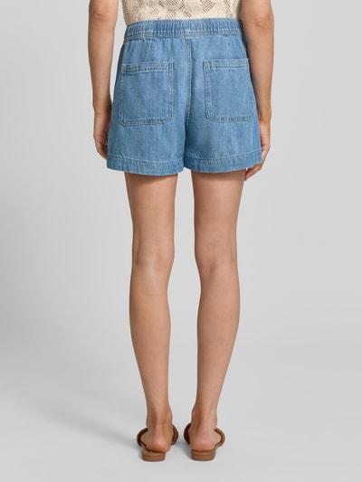 Frauenmodel trägt Straight Fit Shorts in Denim-Optik von GAP aus reiner Baumwolle mit Eingriff- und Gesäßtaschen, elastischer Bund, Ganzkörperansicht Rückansicht.