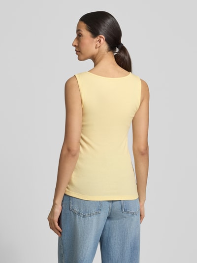 Frauenmodel trägt Slim Fit Top mit Logo-Print von GAP in Gelb aus elastischem Baumwoll-Mix, Rundhalsausschnitt, Rückenlänge 58 cm, Ganzkörperansicht Rückansicht.