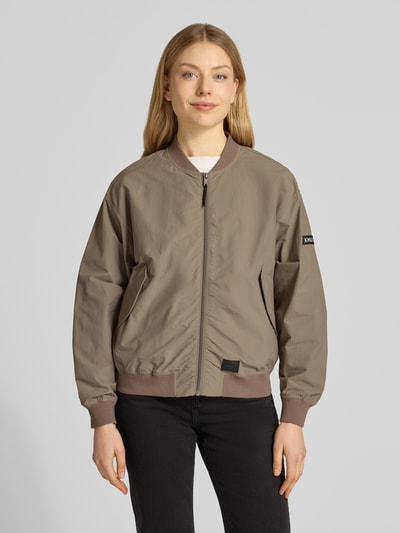 Frauenmodel trägt Jacke mit Pattentaschen Modell 'FACEE' von khujo in Taupe, Regular Fit, Stehkragen, Reißverschluss, Ganzkörperansicht von vorne.