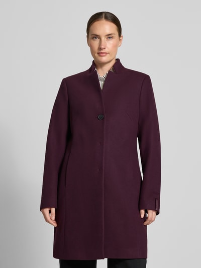Frauenmodel trägt Mantel mit Viskose-Anteil von COMMA in dunklem Violett, tailliert, Stehkragen, Knopfverschluss, Ganzkörperansicht von vorne. Elastischer Material-Mix, Rückenlänge 90 cm, Schulterbreite 38 cm, Brustweite 47 cm, Ärmellänge 64 cm.