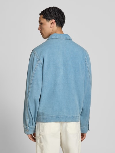 Männermodel trägt Regular Fit Jeansjacke aus reiner Baumwolle Modell 'ELZO' von HUGO Blue, hellblau, strukturierte Webware, Ganzkörperansicht Rückansicht.
