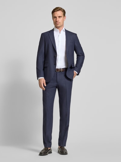 Männermodel trägt Regular Fit Anzughose mit Schurwoll-Anteil Modell 'Leon' von BOSS in Dunkelblau, Ganzkörperansicht von vorne, Herren Anzughose von BOSS.