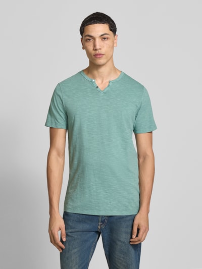 Männermodel trägt T-Shirt aus Baumwolle Modell 'SPLIT' von Jack & Jones, grün, gerader Schnitt, V-Ausschnitt, Ganzkörperansicht von vorne