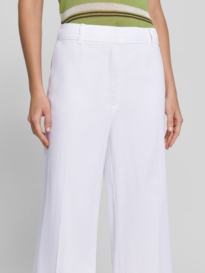 Frauenmodel trägt Chino aus Leinen-Mix mit Bügelfalte Modell 'CALIFORNIA' von Cambio, weiß, gerade Form, Nahaufnahme Oberkörper. Damen-Chino mit Baumwoll-Anteil, Haken- und Reißverschluss, französische Eingrifftaschen, Gesäßtaschen, glatte Textur.