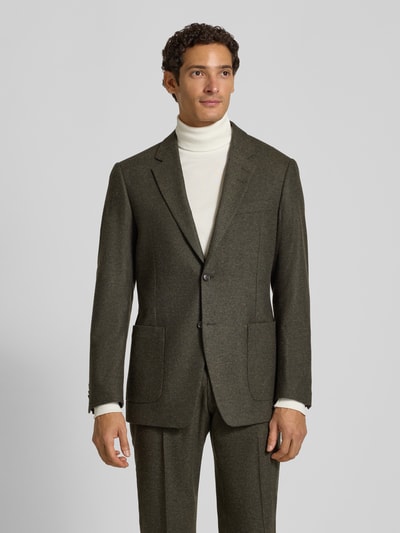 Männermodel trägt Slim Fit Sakko aus reiner Viskose Modell 'Justin' von Tiger of Sweden in Olivgrün, feine Textur, Ganzkörperansicht von vorne. Rückenlänge 76 cm, Schulterbreite 38 cm, Ärmellänge 64 cm, Reverskragen, Knopfleiste, aufgesetzte Taschen, Label-Patch.