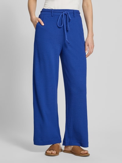 Frauenmodel trägt Wide Fit Stoffhose aus Viskose-Mix Modell 'Lumina' von ICHI in Blau mit Strukturmuster, Abnehmbare Stoffkordel, Gesäßtaschen, Nahaufnahme Oberkörper. Kontext: Damen Stoffhose, elastischer Viskose-Mix, Wide Fit, Bundweite 39 cm, Innenbeinlänge 72 cm bei Größe S.