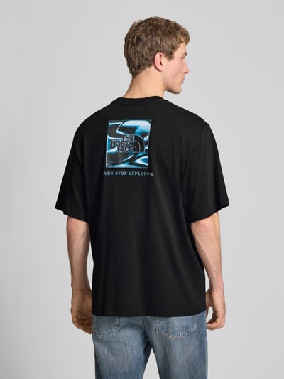 Männermodel trägt Oversized T-Shirt mit Logo und Rundhalsausschnitt von The North Face aus reiner Baumwolle, Rückenlänge 73 cm, Ganzkörperansicht Rückansicht.