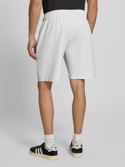 Männermodel trägt Shorts mit Logo Modell 'Troy' von Pegador aus weißem Material-Mix mit Stretch-Anteil, Regular-Fit, Bund, Ganzkörperansicht Rückansicht.
