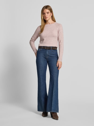 Frauenmodel trägt Regular Fit Pullover mit Rundhalsausschnitt Modell 'DOFFY' von VERO MODA in zartem Rosa, glatte Textur, Ganzkörperansicht von vorne.