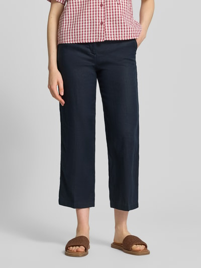 Frauenmodel trägt Leinenhose in verkürzter Passform von Christian Berg Woman, dunkelblau, mit Eingrifftaschen und Paspeltaschen, Reines Leinen, Ganzkörperansicht von vorne.