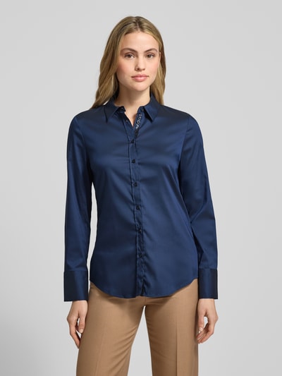 Frauenmodel trägt Hemdbluse mit Knopfleiste von ETERNA in Dunkelblau, lockerer Schnitt, Kentkragen, glatte Oberfläche, Ganzkörperansicht von vorne.