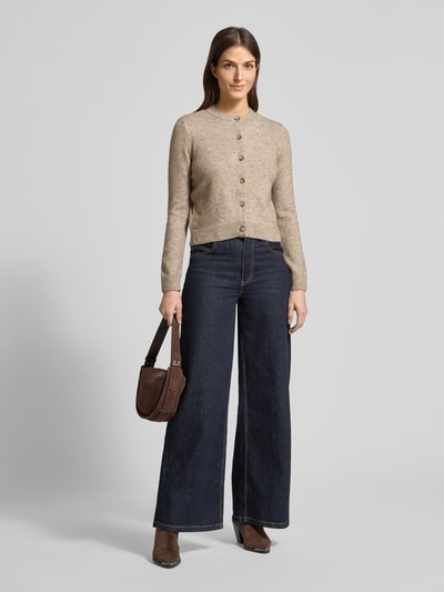 Frauenmodel trägt Regular Fit Cardigan mit Woll-Anteil Modell 'Nekka' von Mango, beige, Rundhalsausschnitt, Knopfleiste, Ganzkörperansicht von vorne.