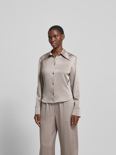 Frauenmodel trägt Hemdbluse mit Spitzkragen von Nanushka aus Satin in Beige, taillierte Passform, durchgängige Knopfleiste, langärmelig, Rückenlänge 58 cm, Ärmellänge 64 cm, Ganzkörperansicht von vorne.