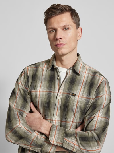 Männermodel trägt Regular Fit Freizeithemd aus reiner Baumwolle von camel active in Grün-Orange-Karomuster, Kentkragen, Brusttasche, Nahaufnahme Oberkörper.