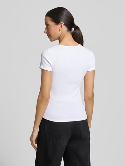 Frauenmodel trägt T-Shirt in Ripp-Optik mit Logo von GAP, weiß, Baumwoll-Mix mit Modal-Anteil, Slim-Fit, Rundhalsausschnitt, Rückenlänge 53 cm, Ganzkörperansicht Rückansicht.