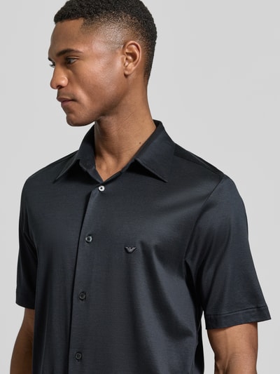 Männermodel trägt Regular Fit Freizeithemd aus Lyocell-Mix von Emporio Armani in Schwarz mit Kentkragen und Knopfleiste, Nahaufnahme Oberkörper.
