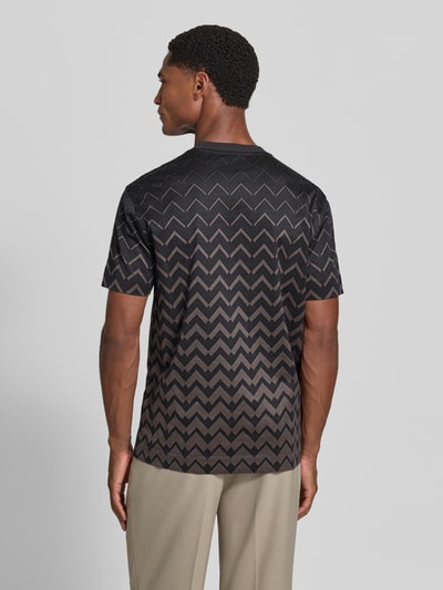 Männermodel trägt T-Shirt mit Rundhalsausschnitt von Emporio Armani, Baumwoll-Lyocell-Mix, gerader Schnitt, dunkle Zickzack-Muster, Rückenlänge 71 cm, Ganzkörperansicht Rückansicht.