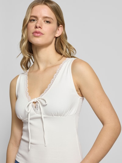 Frauenmodel trägt Trägertop in Ripp-Optik mit Spitzenbesatz von Gina Tricot, Baumwoll-Elasthan-Mix, Slim-Fit, Nahaufnahme Oberkörper.