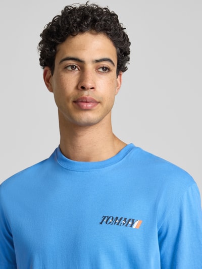 Männermodel trägt Regular Fit T-Shirt aus reiner Baumwolle von Tommy Jeans, Optik: Unifarben, Label-Print, Nahaufnahme Oberkörper.