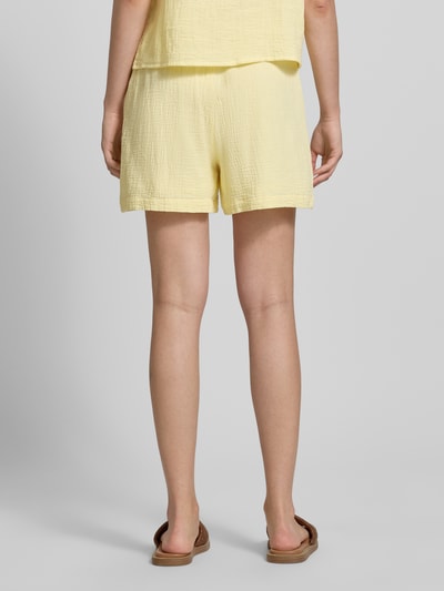 Frauenmodel trägt Comfort Fit Shorts aus reiner Baumwolle Modell 'SASTINA' von Pieces, efekt: jednolity kolor, muślin, wpuszczane kieszenie, elastyczny ściągacz, tunel, bawełna; Ganzkörperansicht Rückansicht.