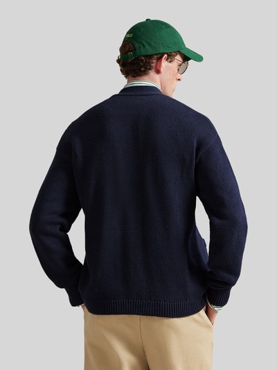 Męski model nosi Regular Fit Strickjacke aus reiner Baumwolle od Polo Ralph Lauren, granatowa dzianina, krój regular fit, widok z tyłu.
