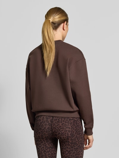 Vrouwenmodel draagt Oversized Sweatshirt aus Baumwolle van Lala Berlin in effen bruin, ribboorden, puur katoen, motiefprint, oversized, ronde hals, ruglengte maat S 60 cm, geheelopname achterkant