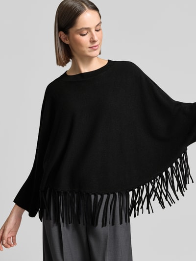 Frauenmodel trägt Relaxed Fit Pullover aus Woll-Mix mit Kaschmir-Anteil von HERZENS, schwarze Strick-Optik, Fransensaum, Nahaufnahme Oberkörper