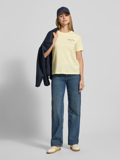 Modelka kobieca nosi T-Shirt mit Label-Print und Rundhalsausschnitt od Gant, jasny żółty, bawełna, regular fit, przód, cała sylwetka.