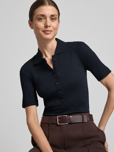 Vrouwenmodel draagt Slim Fit Poloshirt aus Baumwoll-Modal-Mix van Marc O'Polo, effen, ribstructuur, korte mouwen, korte knoopsluiting, label stitching, polokraag, close-up bovenlichaam