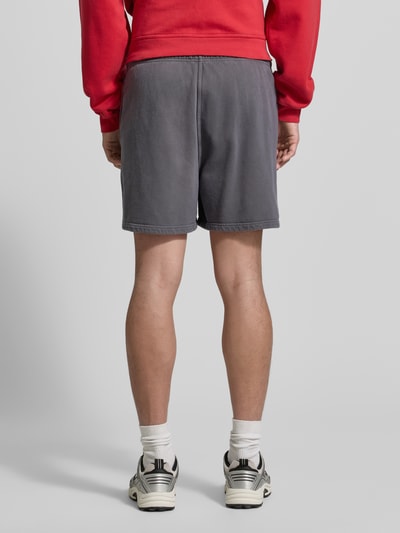 Männermodel trägt Shorts mit Logo Modell 'PLIZZY' von American Vintage, Baumwolle, grau, Relaxed Fit, Rückansicht, Ganzkörperansicht Rückansicht.