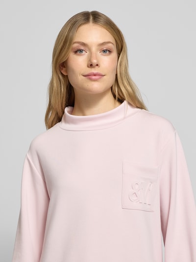 Frauenmodel trägt Sweatshirt mit Stehkragen und Brusttasche von monari in Rosa mit Regular Fit, Modal-Mix und Stretch, Nahaufnahme Oberkörper.