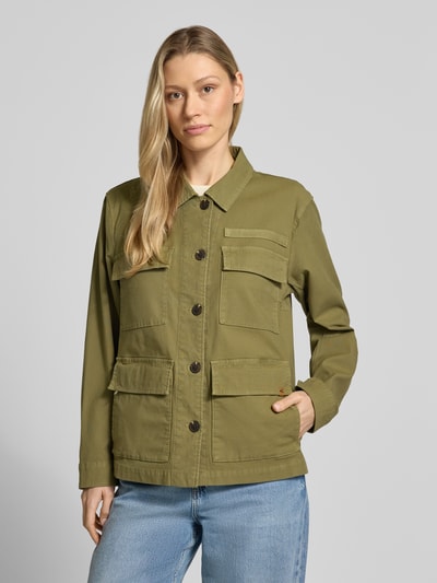 Vrouwenmodel draagt Jacke mit Pattentaschen und Label-Detail van camel active, olijfgroen, rechte fit, katoenmengsel, Kentkraag, knoopsluiting, opgestikte klepzakken, labeldetail, vooraanzicht van het volledige lichaam