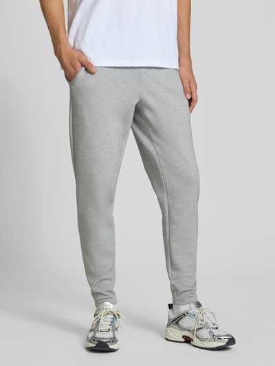 Männermodel trägt Regular Fit Sweatpants mit Lyocell-Anteil von PUMA PERFORMANCE in Hellgrau, elastischer Bund, Logo-Detail, Ganzkörperansicht von vorne.