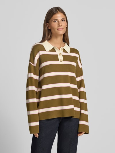 Frauenmodel trägt Pullover aus Viskose-Mix mit Polokragen Modell 'ISABELL' von YAS, olive mit rosafarbenen Streifen, Ganzkörperansicht von vorne.