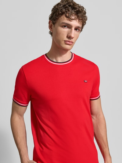 Męski model nosi T-Shirt mit Kontraststreifen und Rundhalsausschnitt von Christian Berg Men, bawełna z domieszką elastanu, krój regular fit, kontrastowe paski, okrągły dekolt, długość tyłu w rozmiarze M: 71 cm, zbliżenie na górną część ciała od przodu