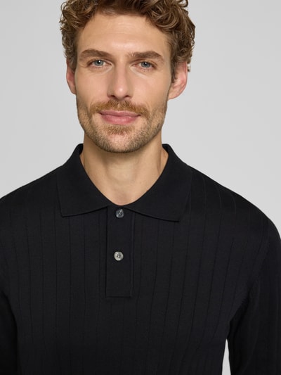 Männermodel trägt Regular Fit Poloshirt aus reiner Baumwolle Modell 'TORINO' von Selected, Farbe Schwarz, Nahaufnahme Oberkörper. Herren Poloshirt.