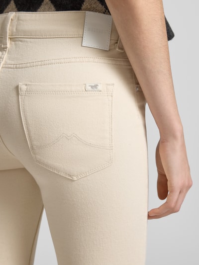 Frauenmodel trägt Flared Fit Jeans im 5-Pocket-Design Modell 'Shelby' von Mustang aus elastischem Baumwoll-Mix in Creme, Detailaufnahme Rücken.