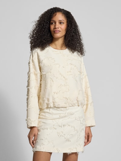 Kobiece model prezentuje Jacke mit Rundhalsausschnitt und Fransen von Jake*s Collection, krój regular fit, okrągły dekolt, frędzle, zapięcie na guzik, długość tyłu w rozmiarze 38: 53 cm, szerokość w rozmiarze 38: 58 cm, długość rękawów w rozmiarze 38: 55 cm, kremowy kolor, faktura z frędzlami, całkowite ujęcie od przodu.