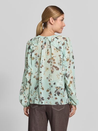 Vrouwenmodel draagt Bluse im Allover-Look mit Volants van Marc Cain in mintgroen met bloemenprint, regular fit, v-hals, ruglengte maat 36: 60 cm, mouwlengte maat 36: 64 cm, all-over look, Volants, Ganzkörperansicht Rückansicht.