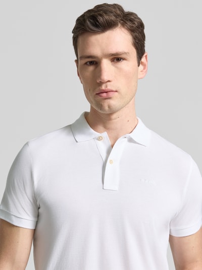 Männermodel trägt Slim Fit Poloshirt mit Logo-Stitching von Geox aus reiner Baumwolle, Strukturmuster, kurzärmelig, Polokragen, Nahaufnahme Oberkörper.