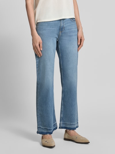 Frauenmodel trägt Cropped Jeans aus Baumwoll-Mix Modell 'C-SOFT KICK FLARE1.0' von BOSS Orange in Denim-Optik mit Flared-Passform, Fransen am Beinabschluss, 5-Pocket-Design, Label-Patch und Nieten, Knopf und verdecktem Reißverschluss, mittleres Blau, Ganzkörperansicht von vorne.