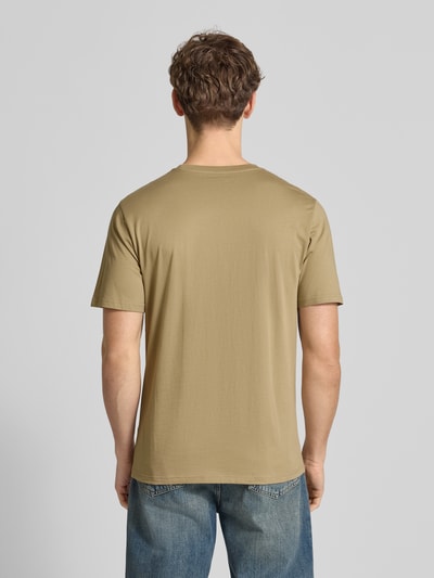 Männermodel trägt Regular Fit T-Shirt mit Logo-Patch von Carhartt Work In Progress, beige Farbe, reine Baumwolle, Rückenlänge 70 cm, Ganzkörperansicht Rückansicht.
