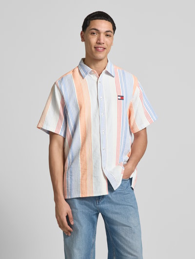 Männermodel trägt Relaxed Fit Freizeithemd aus reiner Baumwolle von Tommy Jeans mit Optik:Allover-Muster, Gestreift, Label-Patch, Ganzkörperansicht von vorne.