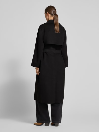 Vrouwenmodel draagt zwarte lange jas Regular Fit Mantel aus Schurwoll-Mix model 'OPEROSO' van Weekend Max Mara, Ganzlichaamsaanzicht achteraan.