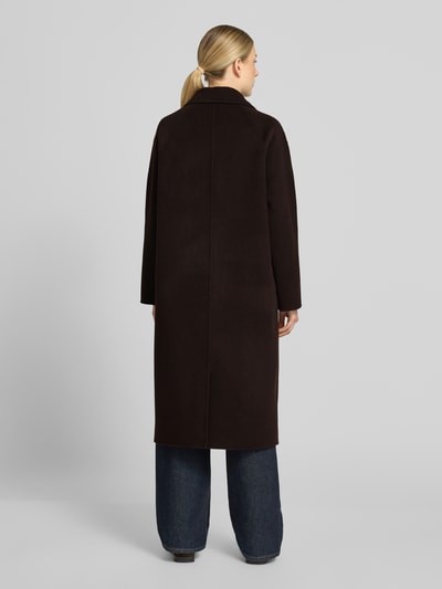 Kobiece model prezentuje płaszcz Relaxed Fit Mantel aus reiner Wolle mit 2-Knopfleiste od Milano Italy, ciemnobrązowy kolor, prosta forma, lekko fakturowana wełna, Kołnierz z połami, Listwa z 2 guzikami, wpuszczane kieszenie, Długość tyłu w rozmiarze 36: 115 cm, Szerokość ramion w rozmiarze 36: 45 cm, Szerokość w rozmiarze 36: 56 cm, Długość rękawów w rozmiarze 36: 55 cm, Ganzkörperansicht Rückansicht