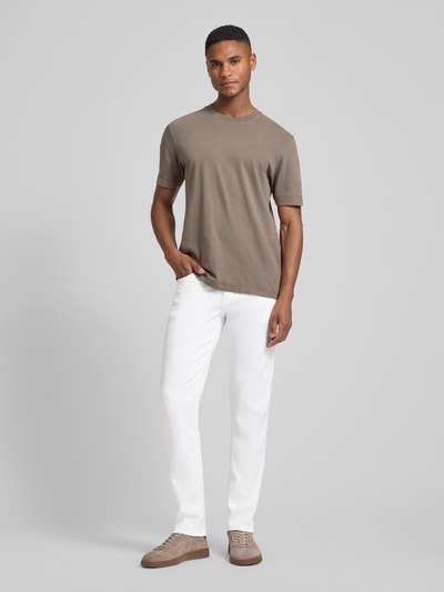 Männermodel trägt Tapered Fit Hose mit Eingrifftaschen Modell 'Lyon' von Pierre Cardin in Weiß, Baumwoll-Elasthan-Mix, Ganzkörperansicht von vorne.