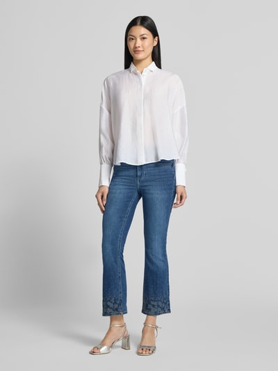 Kobiece modelka ma na sobie Flared Fit Jeans aus Baumwollmix mit Lyocell-Anteil Modell 'Princess' od Liu Jo White, niebieski kolor, mieszanka bawełny i lyocellu, rozkloszowany krój, skrócona długość, obszycie z kamieni stras, 5 kieszeni, zapięcie na guzik i zamek błyskawiczny, Szerokość w rozmiarze 27: 36 cm, Długość wewnętrzna nogawki w rozmiarze 27: 67 cm, Ganzkörperansicht z przodu.