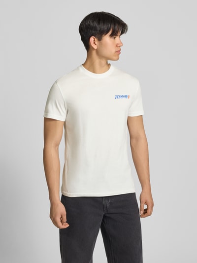 Männermodel trägt Regular Fit T-Shirt aus reiner Baumwolle von Tommy Jeans, Optik: Unifarben, Rundhals, Kurzarm, Label-Print, Jersey, Ganzkörperansicht von vorne.